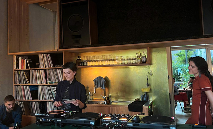 color photo of short hair woman at dj desk