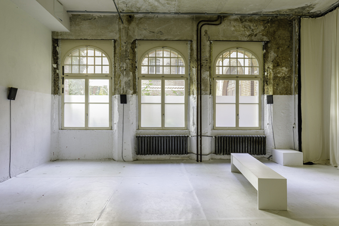 White Space with six speakers, three large windows, and bench