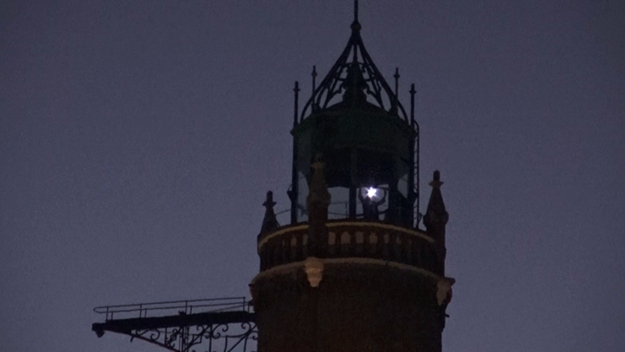 top of lghthouse, with faint figure with head lamp