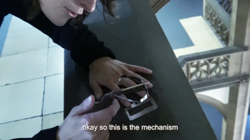 half face of a woman using a minitature crossbow in a neo-gothic staircase