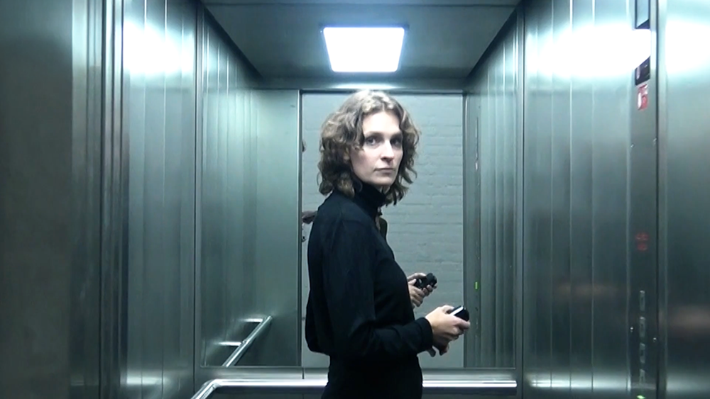 woman facing camera scepticaly inside blue lit elevator